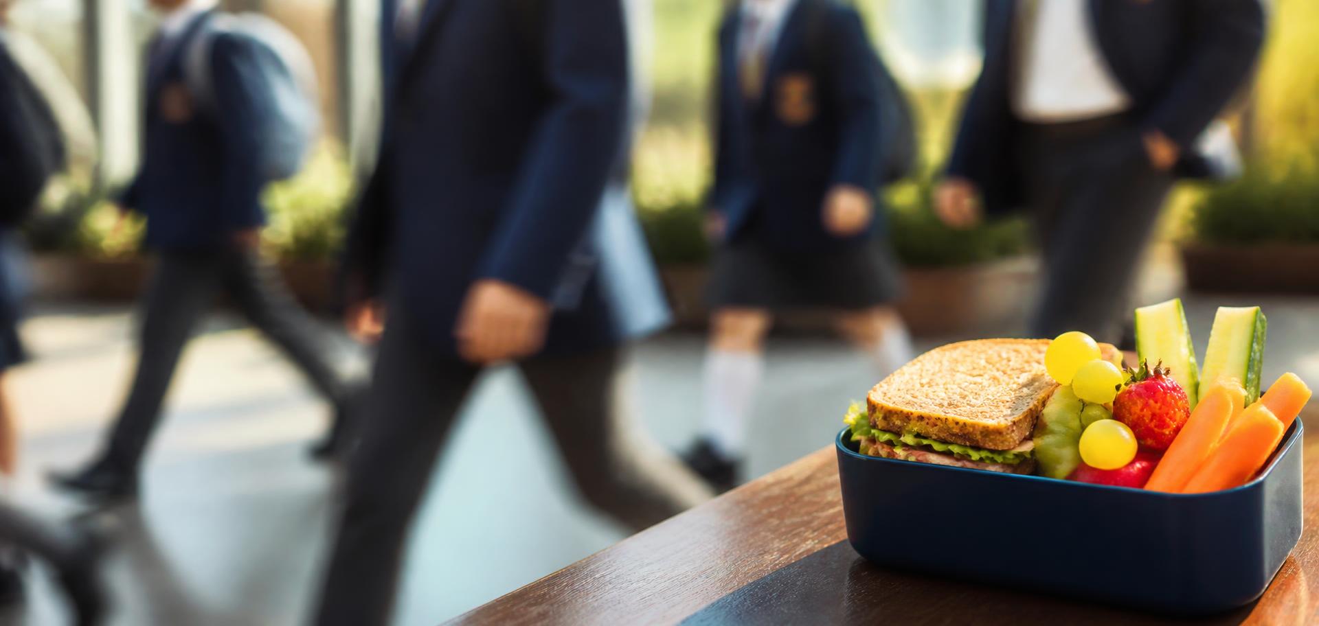 School children walking past a packed lunch box